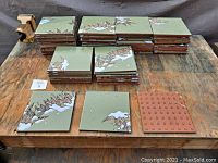 All stacks of vintage green ceramic glazed fired clay tiles on wooden surface.