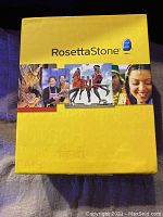 Yellow Rosetta Stone box for Spanish Latin America Version 4 Levels 1-5 language learning software with cultural images.