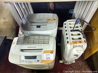 Two Frigidaire air purifiers and one DeLonghi Dragon space heater side by side.