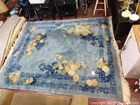 Full view of the 8'x10' blue floral rug showing the central floral design and border.