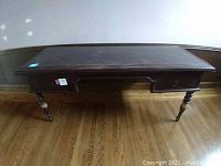 Front view of the dark wood desk showing the rectangular top surface and legs
