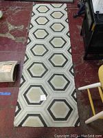 Full view of the rug runner showing hexagonal pattern and its length on floor.