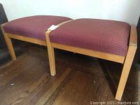 Two-piece red upholstered bench seat with light wood frame on hardwood floor.