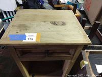 Front view of solid wood nightstand showing drawer with metal pull and open lower shelf