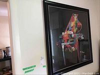 Framed colorful abstract piano print hanging on a wall, showing its general appearance and environment.