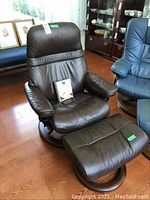 Front view of brown leather chair with ottoman on hardwood floor