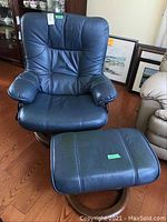 Full view of blue reclining chair and ottoman together on hardwood floor