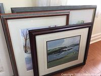 Three framed artworks leaning against a wall showing the sizes and frames.