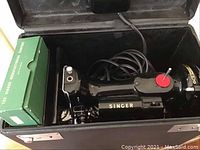 Singer Featherweight 221K5 machine inside its hard carrying case with coiled power cord and green accessory box