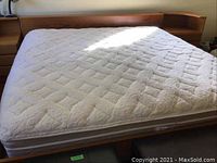 Full front view of bed frame with mattress showing headboard and side shelf compartments