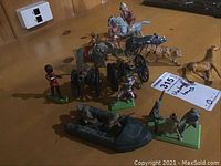 Overview of collection showing toy soldiers, cannons, and several animal figures on a table