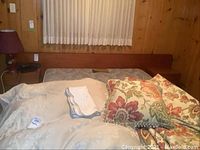 Front view of bed frame with headboard, built-in side tables, bedding and pillows