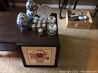 Photo of entire set showing candle holders, ceramic jars, framed plate, and a wooden box with miscellaneous items.