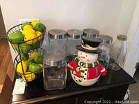 Overall shot of canisters, snowman cookie jar, Italian glass bottle, and two-tier fruit basket