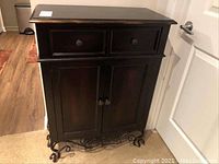 Front view of the Pier 1 wood mini buffet cabinet with wrought iron legs, two doors and one drawer.
