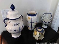 Full set of four Portuguese hand-painted pottery pieces displayed on black surface