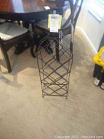 Front view of metal wine rack placed on floor in a room with furniture