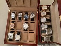 Full view of two wooden watch cases with multiple watches in slots