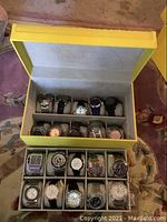 Wide shot of yellow leatherette display case containing two removable trays of watch pillows