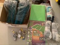 Overall view of watches, socks, hangers, and laundry folding aid in lot