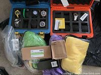 Two foam-padded watch cases (blue and orange) holding seven Invicta watches alongside power bank, speaker, cloths and pen.