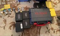Six Invicta watches laid out next to branded boxes and storage case on carpet