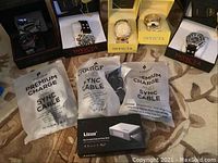 Overview of five Invicta watches in assorted boxes, four Puridea cables in sealed bags, one Lizone power bank box