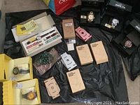 All six Invicta watches in various original boxes, five phone stands and carved stone necklace arranged on floor.
