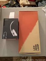 LED desk lamp box and Beats Solo2 headphone box displayed side by side on table.