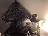 Stained glass table lamp with floral mosaic shade and base on surface