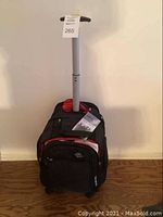 Photo showing the upright black Samsonite rolling suitcase with telescoping handle extended and three front compartments.