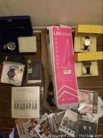 Overview of four Invicta watch boxes, LED lamp box, power bank packaging, crystal shot glass box, and scattered CDs