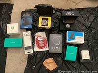 All lot contents arranged on black sheet: watches, chargers, cables and accessories visible