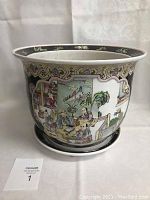 Front view of large ceramic planter and attached saucer, showing colorful Asian design and black patterned border near rim and base.