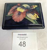 Top view of rectangular Moorcroft ceramic box lid with floral pattern.