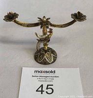 Front view of the brass decorative bird candle holder showing two candle cups and floral base