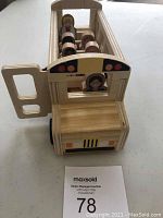 Front-side view of wooden school bus toy with figures inside and open door