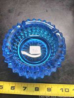 Top view of cobalt blue glass ashtray showing scalloped edge and central smooth area with sticker 90 inside.
