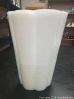 Front view of white milk glass vase showing opaque glossy finish and vertical ridges.