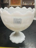 Side view of the vintage milk glass dish showing hobnail pattern, scalloped edge, and pedestal base with a visible hairline crack.