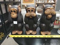 Front view of the 3 Wise Monkeys wood carvings with measuring tape showing approximate height of 8 inches for scale.