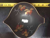 Top view of the vintage German dish showing the black interior with red berries, gold leaves, and gold trim.