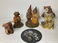 Photo showing all resin cast figures including bear, frog, gnome couple, owl, and oval plaque with rabbit image
