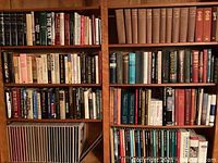 Bookshelves tightly packed with many books both hardcover and softcover across various academic and general interest topics.
