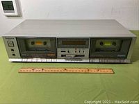 Front view of the Technics RS-B11W stereo double cassette deck showing two cassette compartments and central control panel with buttons and display.