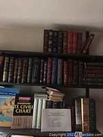 Overall view of shelves with atlas, chart and leather-bound books