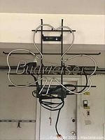 Front view of Budweiser neon sign in the shape of a four-leaf clover with Budweiser written across it in neon tubing.