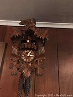 Carved wood cuckoo clock hanging on paneled wall