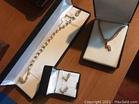 Complete costume jewelry set with necklace, bracelet, and earrings in boxes