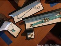 Full view of the jewelry set including necklace, bracelet, ring, and Holsted watch in display boxes.